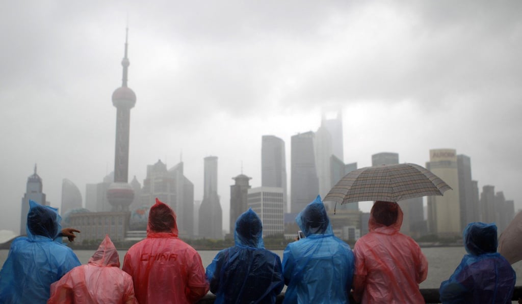 Tourists view Shanghai’s financial district across the Huangpu River from the Bund. China’s corporate debt has soared to 166 per cent of GDP. Photo: AP