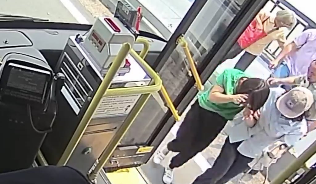 Footage shows the woman, dressed in a green top, being helped onto a bus after she was pulled away from the edge of the bridge. Photo: PearVideo