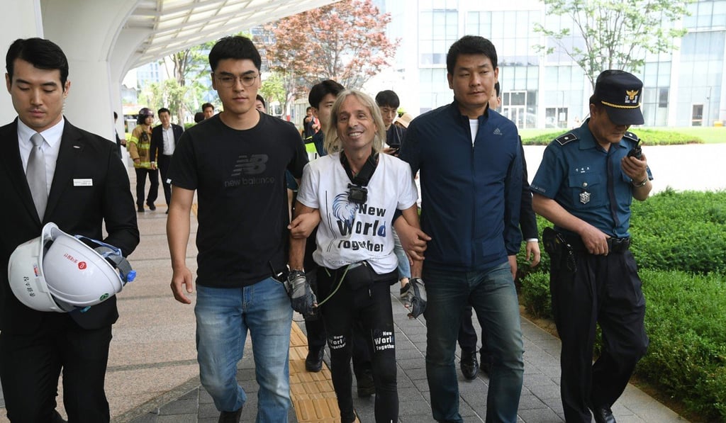 French Spiderman Alain Robert is arrested after climbing the Lotte World Tower in Seoul. Photo: AFP