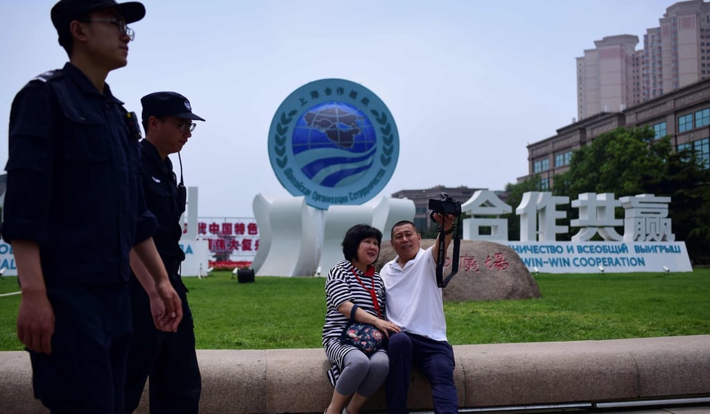 A couple take a selfie in front of a Shanghai Cooperation Organisation sign in Qingdao on Friday. Photo: AFP A couple take a selfie in front of a Shanghai Cooperation Organisation sign in Qingdao on Friday. Photo: AFP