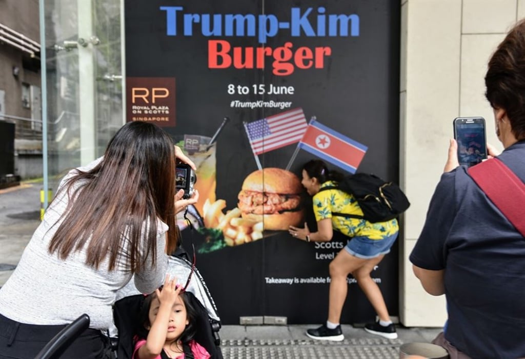 Visitors take photos of the Trump-Kim Burger poster set up by Royal Plaza on Scotts. The five-star hotel introduced the summit-themed meal to mark tomorrow’s historic meeting between US President Donald Trump and North Korean leader Kim Jong-un. Photo: Kim Jae-kyoung Visitors take photos of the Trump-Kim Burger poster set up by Royal Plaza on Scotts. The five-star hotel introduced the summit-themed meal to mark tomorrow’s historic meeting between US President Donald Trump and North Korean leader Kim Jong-un. Photo: Kim Jae-kyoung