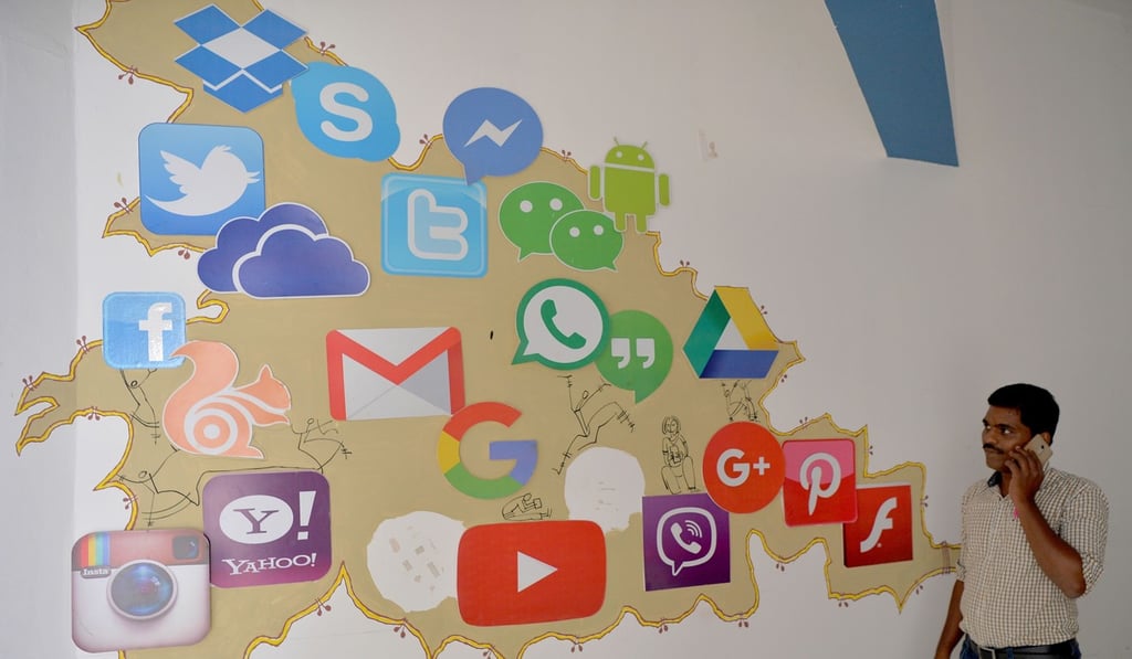 An Indian visitor passes a mural depicting various social medias inside a building in Bangalore. Photo: AFP