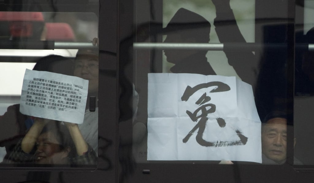 Petitioners detained on a bus hold a sign reading “unjust” near Peking University in Beijing in 2009. Beijing has clamped down on petitioning in recent years. Photo: AP