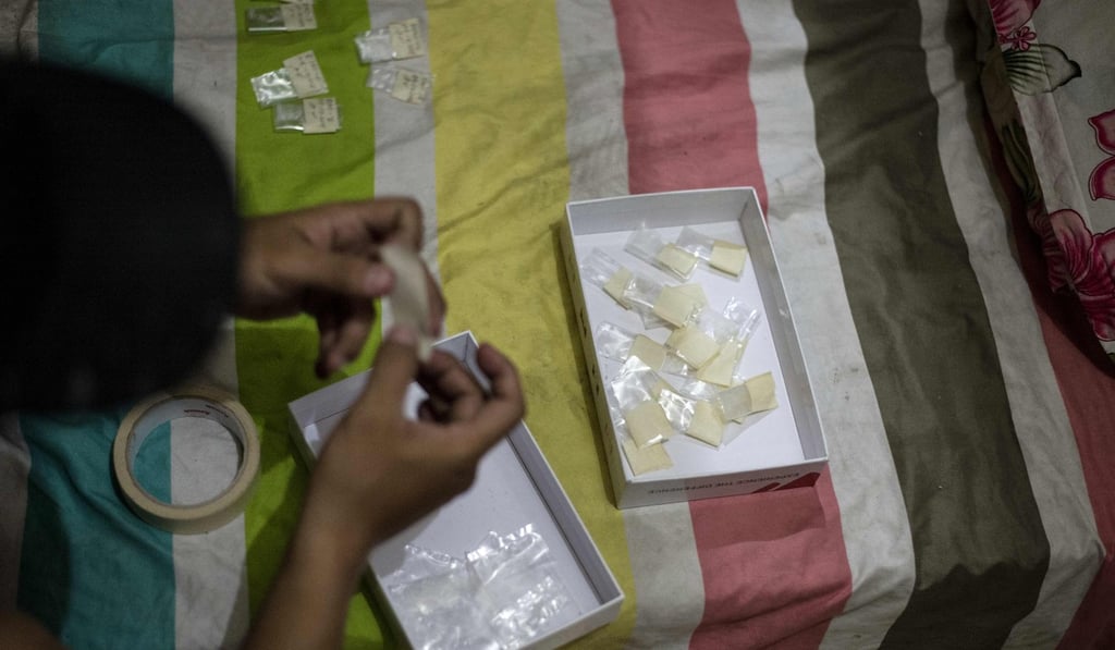 People examine confiscated drugs after a police raid on a drug den in Manila. The Philippines’ interior ministry said on Wednesday it plans to acquire pistols for community leaders willing to fight crime and drugs. Photo: AFP