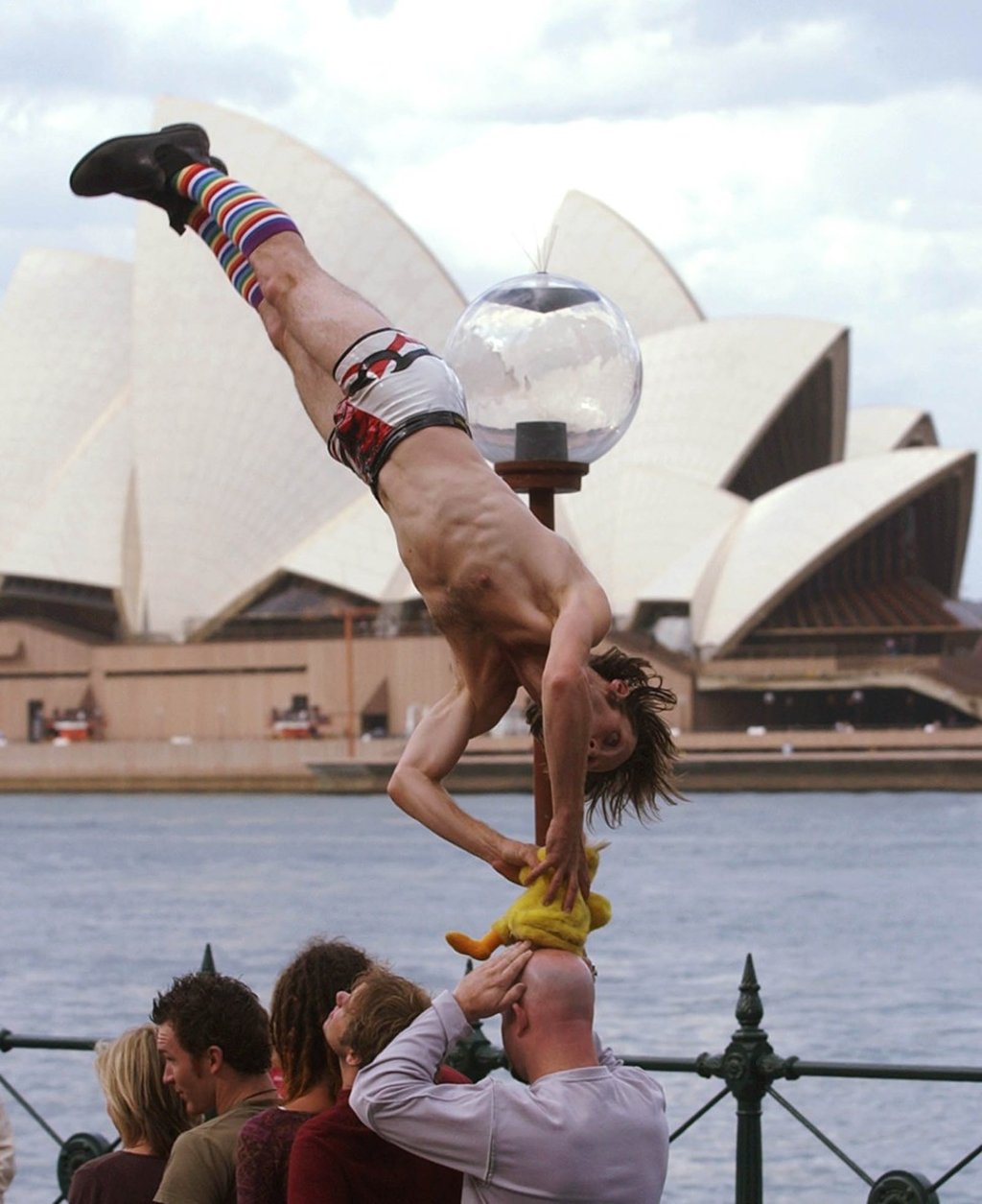 Street performer Hemlock Mejarne flies over audience volunteers during a acrobatic show at Sydney's Circular Quay. Local governments in Australia issue permits to street performers, a system some have called for Hong Kong to consider. Photo: AP