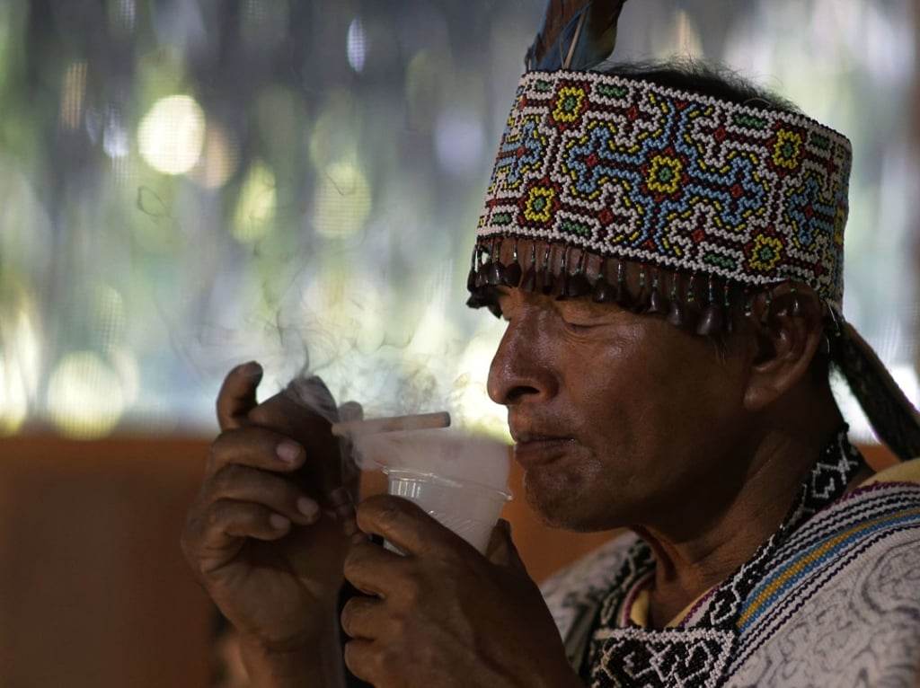 Flores prepares to drink ayahuasca during the ritual in Nuevo Egipto, Peru. Photo: AP