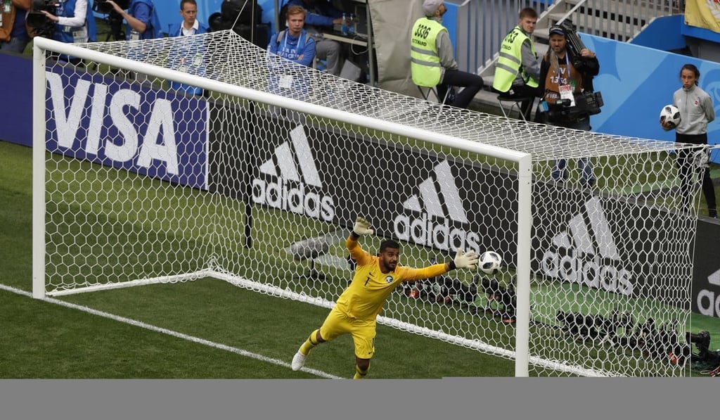 Saudi Arabia goalkeeper Abdullah Almuaiouf makes an attempt to stop Golovkin’s free-kick. Photo: AP