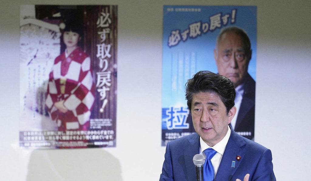 In front of Abduction Issue Awareness posters, Japanese Prime Minister Shinzo Abe speaks in April to families of Japanese citizens abducted by North Korea. Photo: AP
