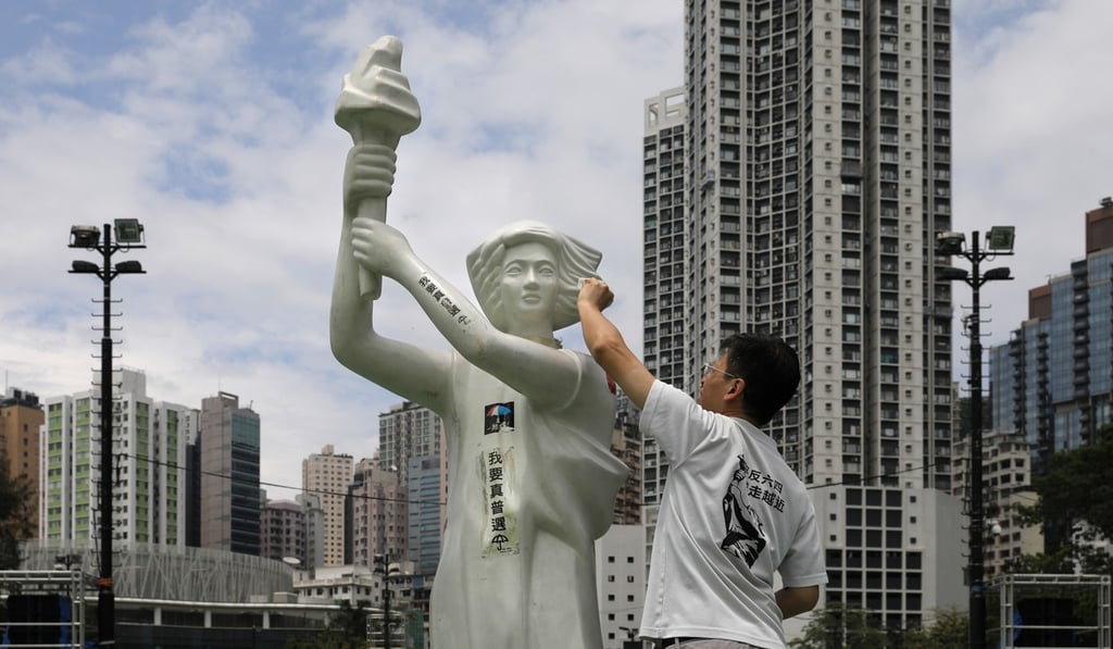 A man wipes the face of a statue of the Goddess of Democracy at Victoria Park on June 4, ahead of the annual candlelight vigil to remember the victims of the Chinese government's military crackdown in Beijing's Tiananmen Square in 1989. Photo: AP