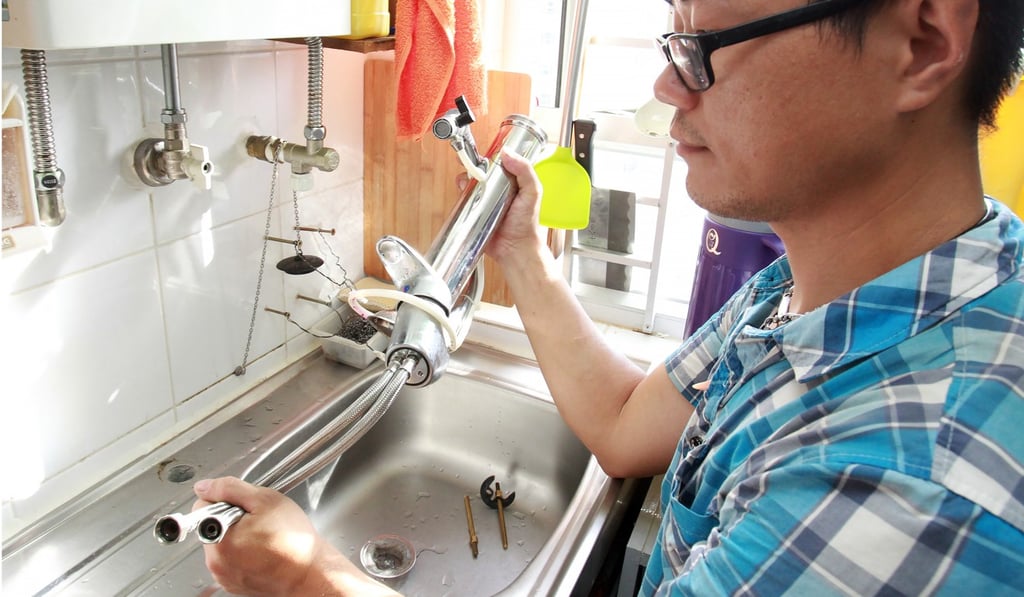 A worker inspects taps at a flat in Tak Long Estate at Kai Tak. Photo: May Tse