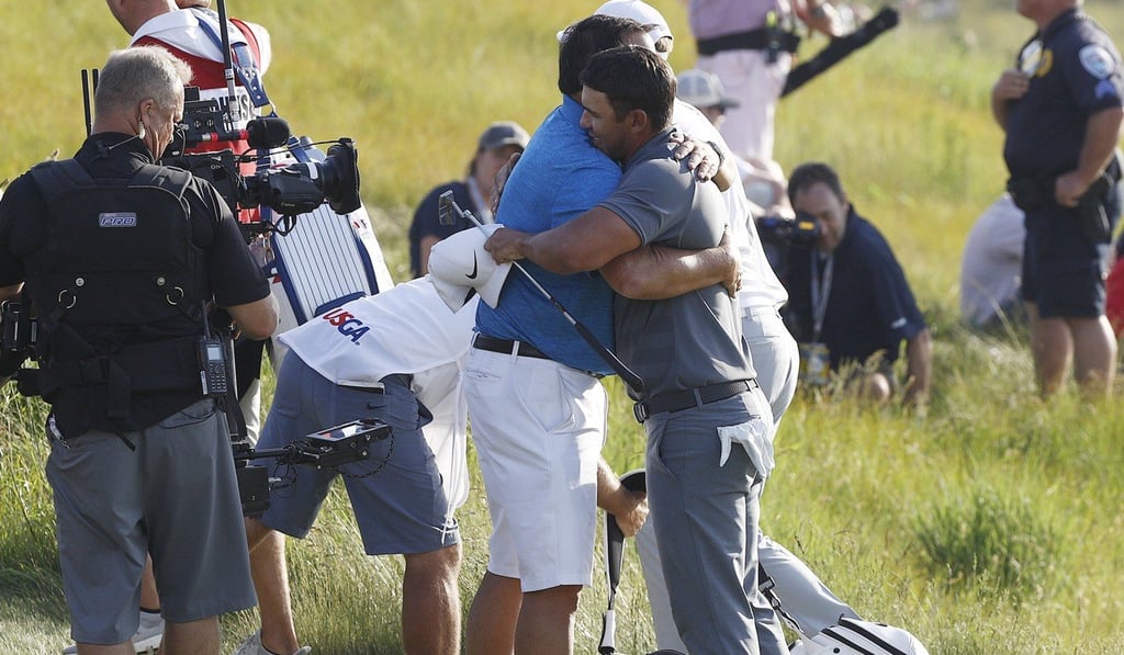 Brooks Koepka embraces his father, Bob, after sinking his final putt. Photo: EPA
