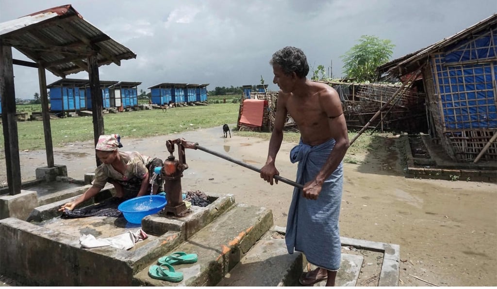 A Rohingya man wearing a sarong washing clothes at a camp in Sittwe, Rakhine State. Photo: AFP