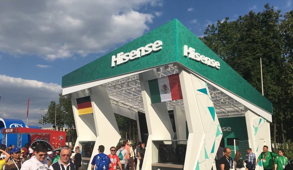 Fans pass the Hisense booth in a fan zone at the World Cup.