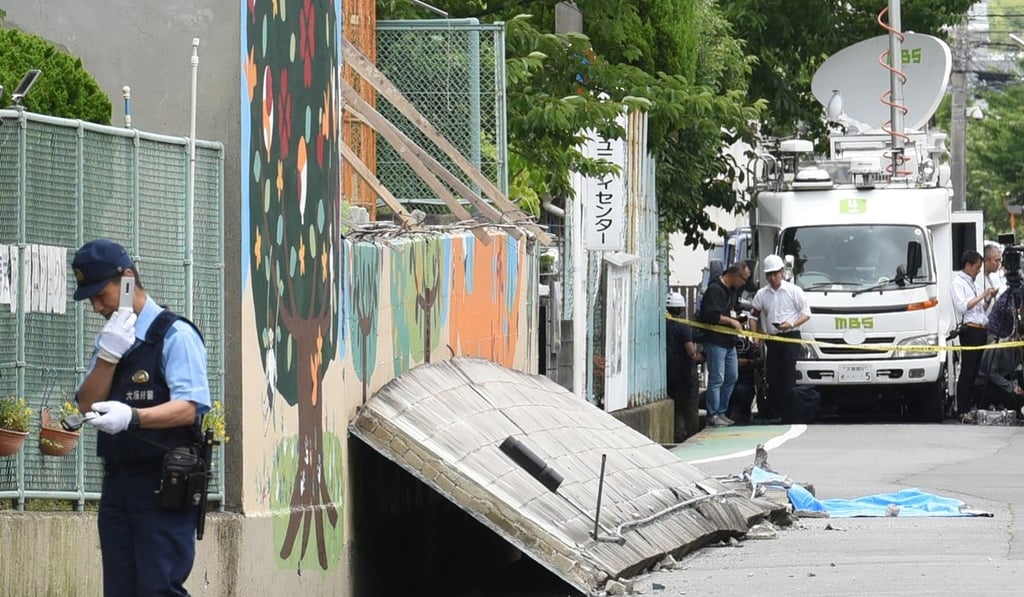 A policeman stands guard near a collapsed wall where a girl died. Photo: AP A policeman stands guard near a collapsed wall where a girl died. Photo: AP