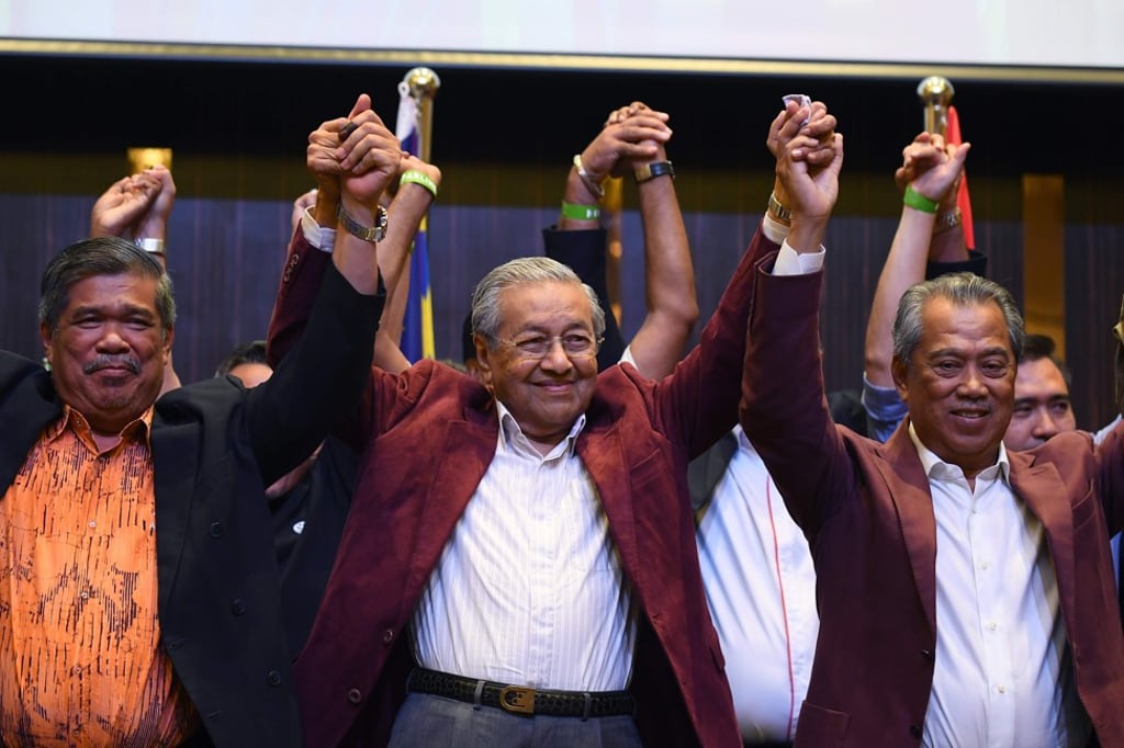 Mahathir Mohamad, center, celebrates with other leaders of his coalition during a press conference following the general elections in Kuala Lumpur, Malaysia in May. Photo: AFP
