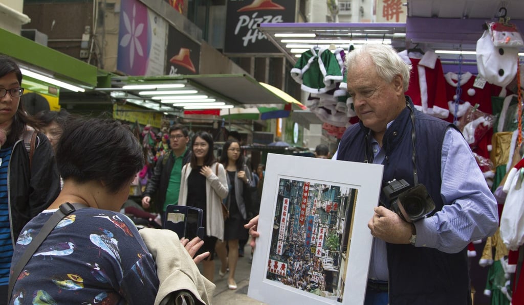 Photographer Keith Macgregor poses with one of his images at Tai Yuen Street, Wan Chai. The street, with its variety of shops and stalls, has a lively community feel. Photo: James Wendlinger