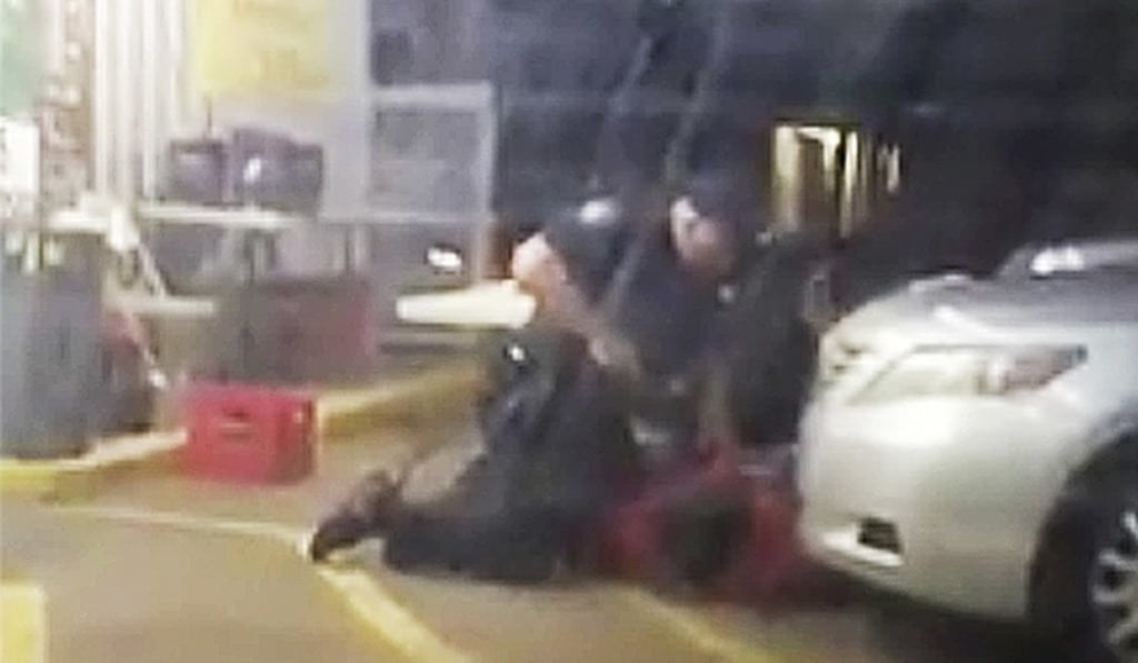Alton Sterling being restrained by two Baton Rouge police officers, one holding a gun, outside a shop in Baton Rouge. Moments later one of the officers shot and killed Sterling, a black man who had been selling CDs outside the shop. Photo: AP