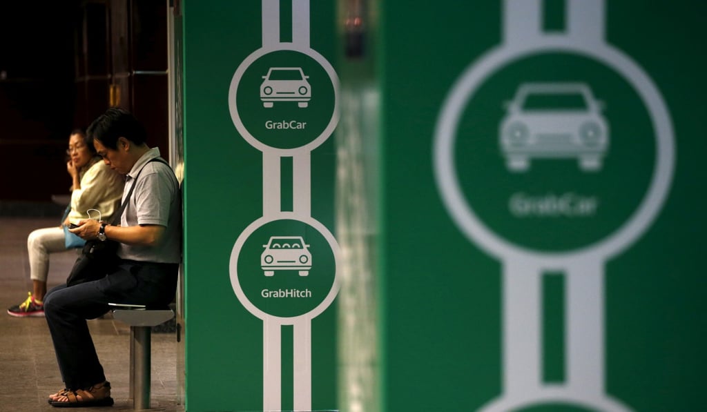 Commuters wait for a train next to Grab transport booking service app advertisements at a train station in Singapore February 10, 2016.REUTERS/Edgar Su/File Photo