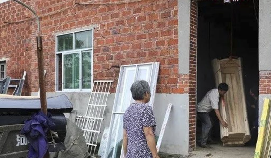 A resident hands over a coffin in Gaoan county, Jiangxi province. Photo: Thepaper.cn