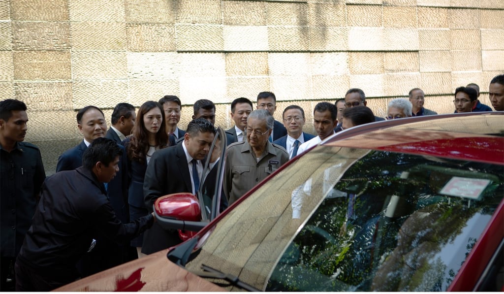 Malaysia’s Prime Minister Mahathir Mohamad and the new Proton Holdings sport utility vehicle. Photo: Bloomberg
