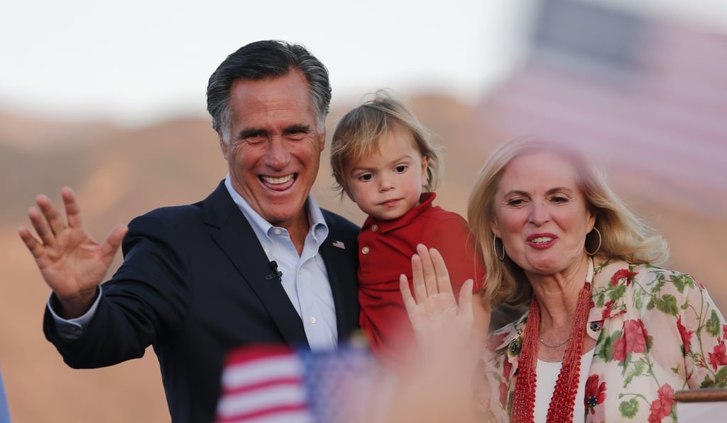 Mitt Romney holds his grandson Dane Romney, 2, while he and his wife, Ann, wave after addressing supporters at their campaign headquarters during an election night party on Tuesday in Orem, Utah. Photo: AP