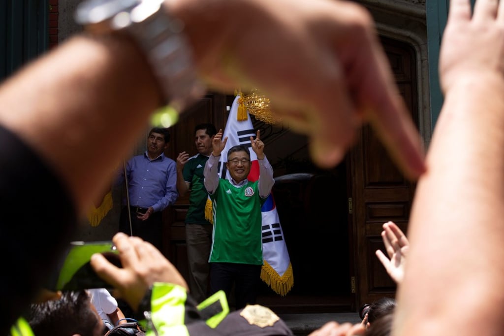 South Korea’s consul general in Mexico, Han Byoung-jin, cheers as Mexican fans celebrate outside the embassy. Photo: Reuters