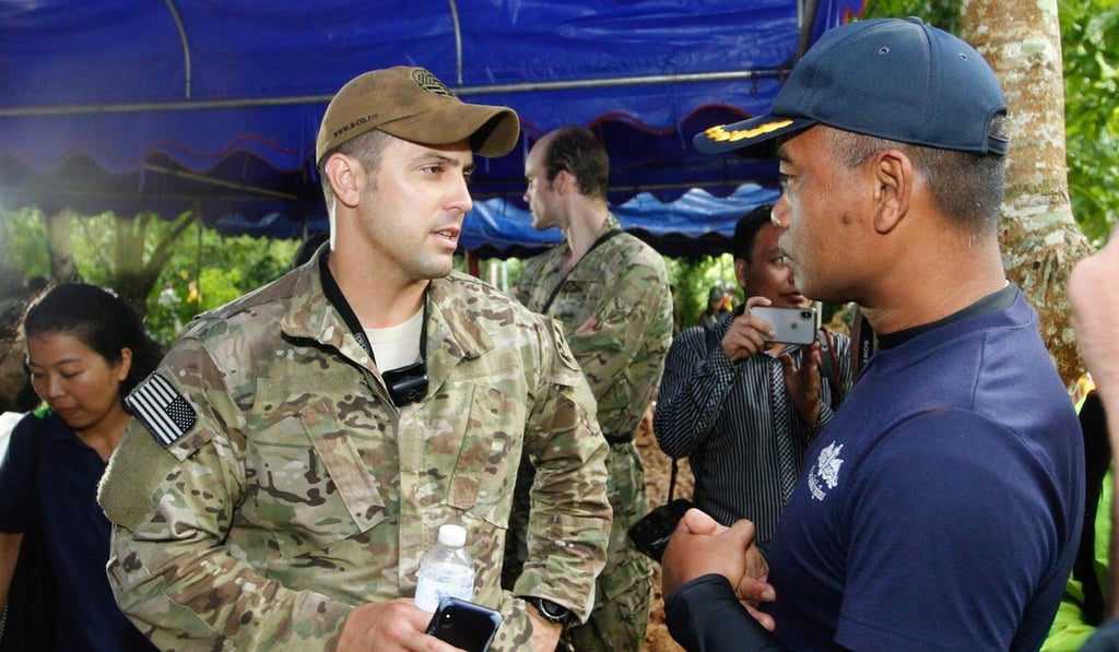 A US Special Operations Command Pacific Search and Rescue Team member talks to Thai Navy personnel after they inspect the cave area where at least 12 members of a youth soccer team are believed to be trapped. Photo: EPA A US Special Operations Command Pacific Search and Rescue Team member talks to Thai Navy personnel after they inspect the cave area where at least 12 members of a youth soccer team are believed to be trapped. Photo: EPA