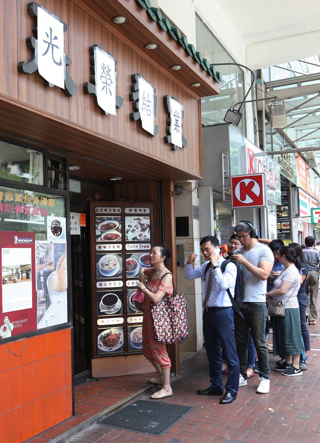 A queue of people waits outside Wing Wah, which has covered its name with Chinese characters that read “closing down”. Photo: Tory Ho