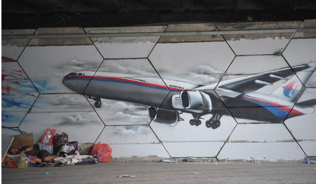 A homeless person sleeps under a mural in Kuala Lumpur. Photo: Alamy