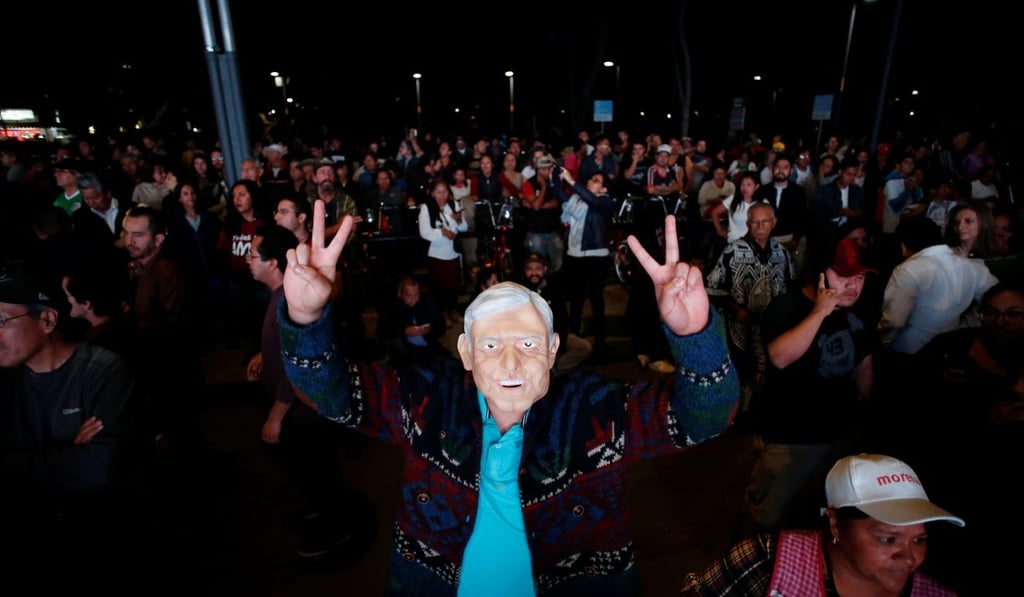 Supporters of presidential candidate Andres Manuel Lopez Obrador, one in a mask of the candidate, celebrate in Mexico City on Sunday. Photo: Reuters