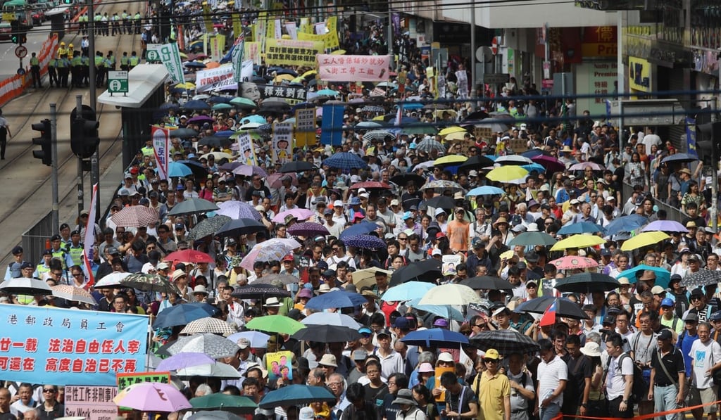 Crowds on the July 1 rally holds up banners on Causeway Road. Photo: Sam Tsang