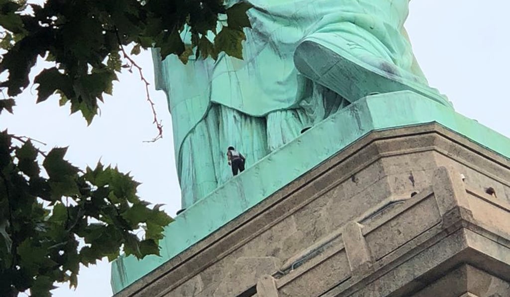 A protester is seen on the Statue of Liberty in New York. Photo: Reuters