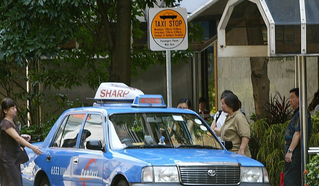 Passengers board taxi at a stand on the street in Singapore AFP PHOTO