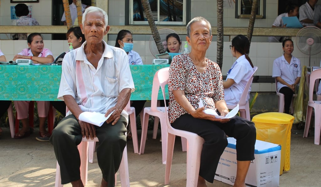 Cambodian rice farmer Peng Nean (R) and her neighbour wait for the doctors. Photo: Kinling Lo