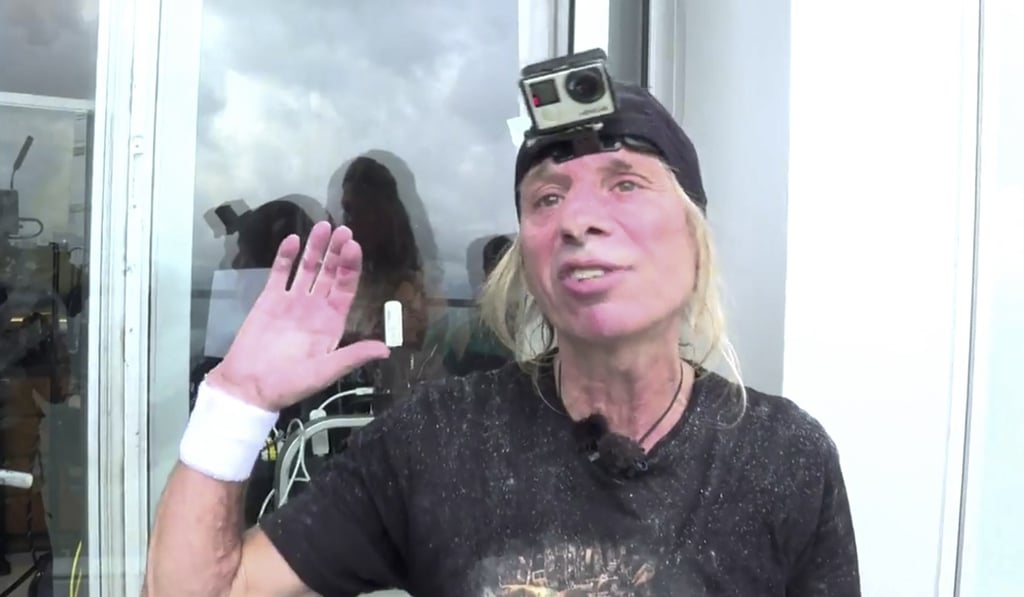 French daredevil Alain Robert records a video after climbing the Hong Kong Four Seasons Hotel on Saturday morning. Photo: Skyscraper Climb