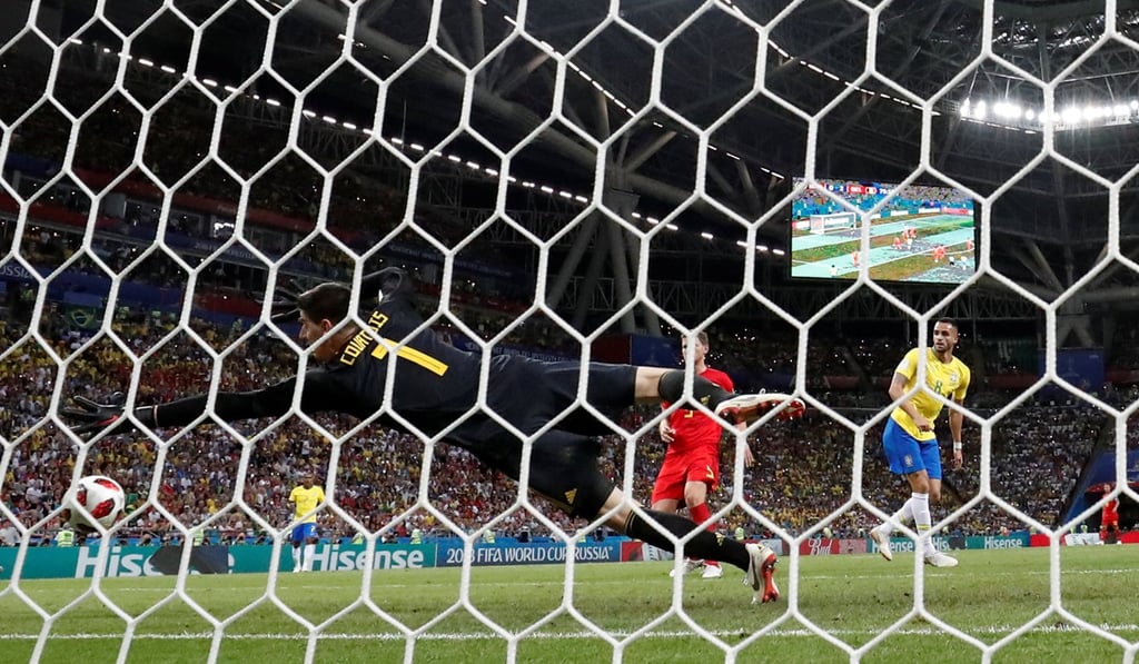 Brazil’s Renato Augusto scores one past Belgium’s Thibaut Courtois. Photo: Reuters
