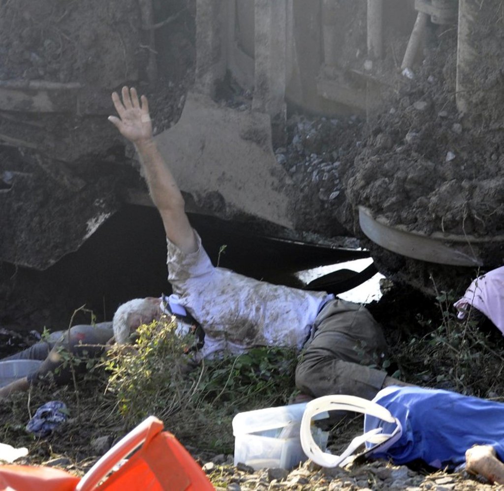 A victim of Sunday’s Turkish train derailment raises his arm to signal rescuers on Sunday. Photo: EPA