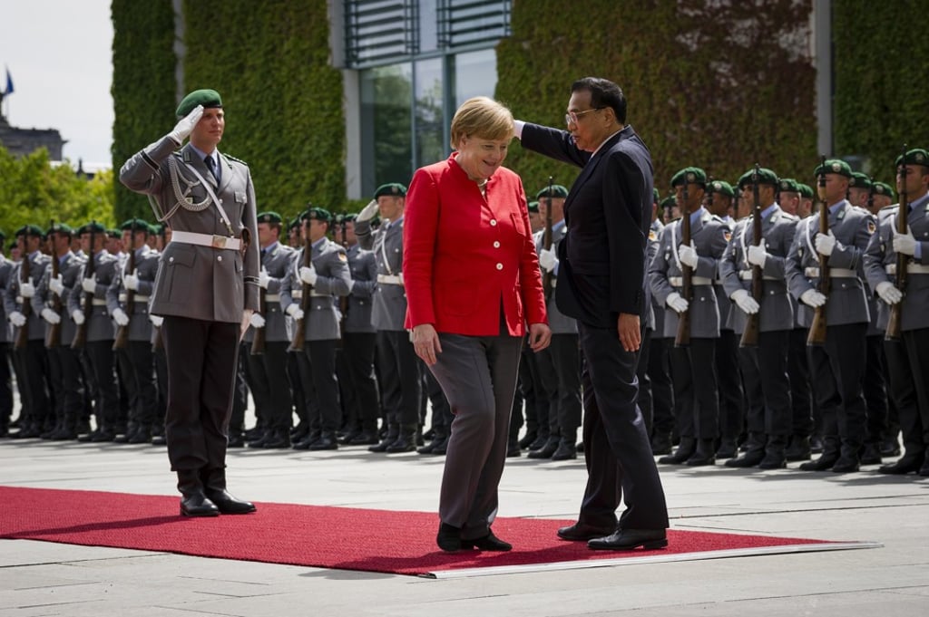 Angela Merkel reacts while reviewing an honour guard with Li Keqiang in Berlin. Photo: Bloomberg