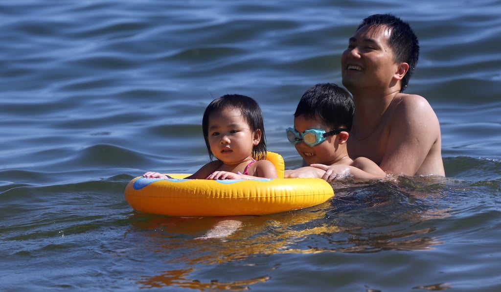 A man swims happily with his kids at Repulse Bay Beach during a hot day last month. Photo: Sam Tsang