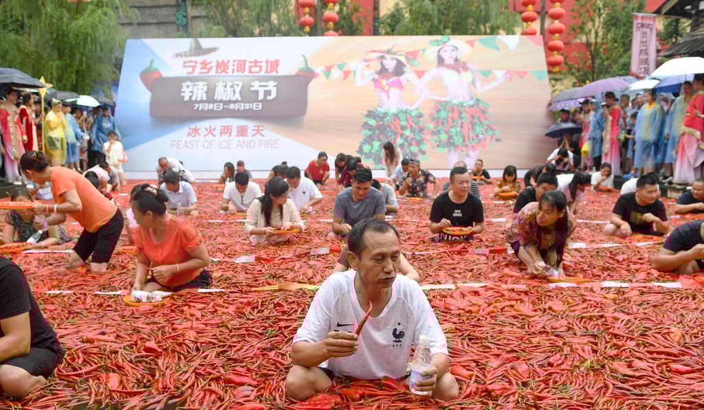 Competitors sat in a shallow pool filled with water and three tonnes of floating chillies. Photo: AFP