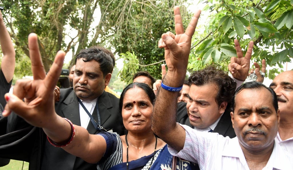 Asha Devi, second from left, mother of 2012 Delhi bus gang rape case victim Nirbhaya, flashes the victory sign to the media in New Delhi, India, on July 9. India’s top court Monday upheld the death penalty for three men convicted in the case. Photo: Xinhua