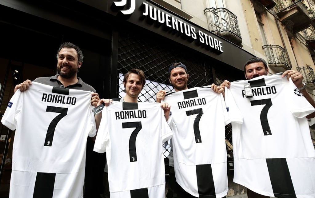 Juventus supporters show their Cristiano Ronaldo Jerseys in front of the club store in Turin. Photo: AFP Juventus supporters show their Cristiano Ronaldo Jerseys in front of the club store in Turin. Photo: AFP