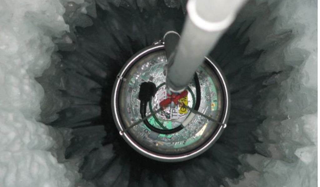 An Ice Cube sensor is dropped into a 2.5km deep hole in the Antarctic ice, to detect neutrinos. Photo:. National Science Foundation / Mark Krasberg