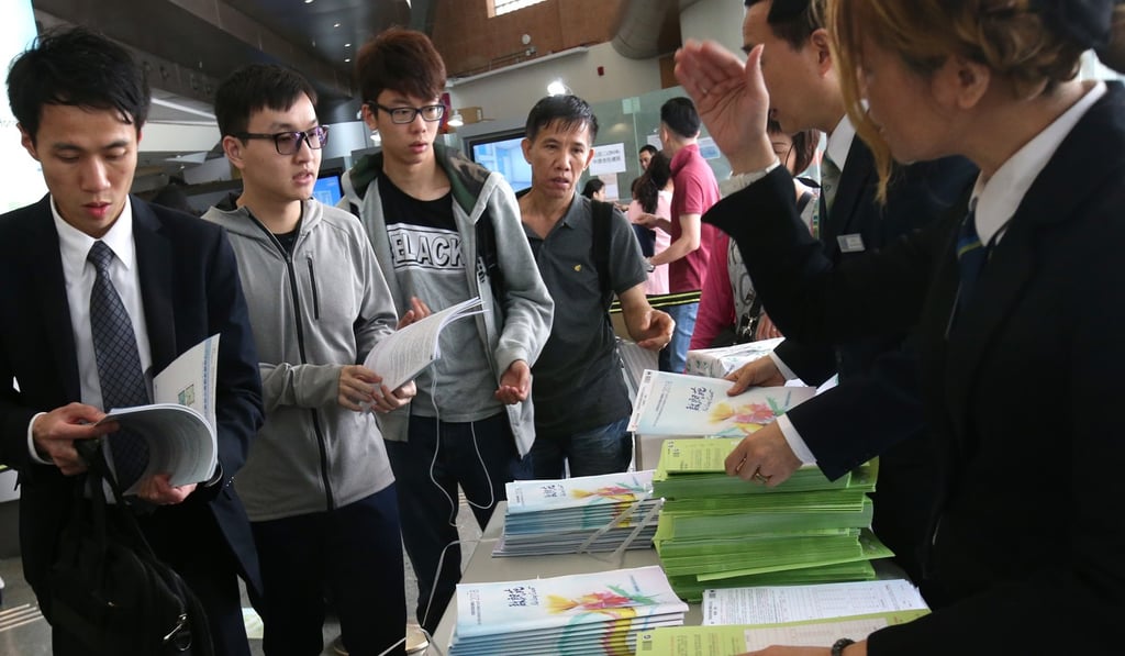 People take application forms for the sale of home ownership scheme flats for the Kai Long Court in Kai Tak. Photo: David Wong