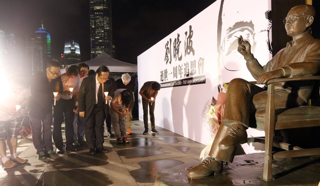 Alliance in Support of Patriotic Democratic Movements of China officials pay their respects to a statue of Liu Xiaobo’s in Tamar Park. Photo: Felix Wong