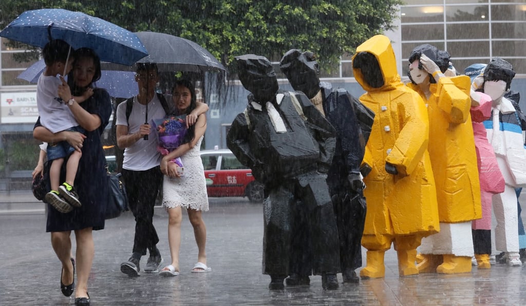 The heavy rainfall in Tsim Sha Tsui doesn’t appear to bother the pedestrians or the artworks. Photo: Felix Wong