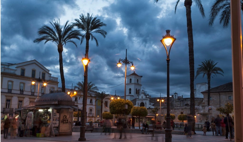 People walking and playing in the Plaza Mayor de Merida during the evening hours. Photo: Alamy