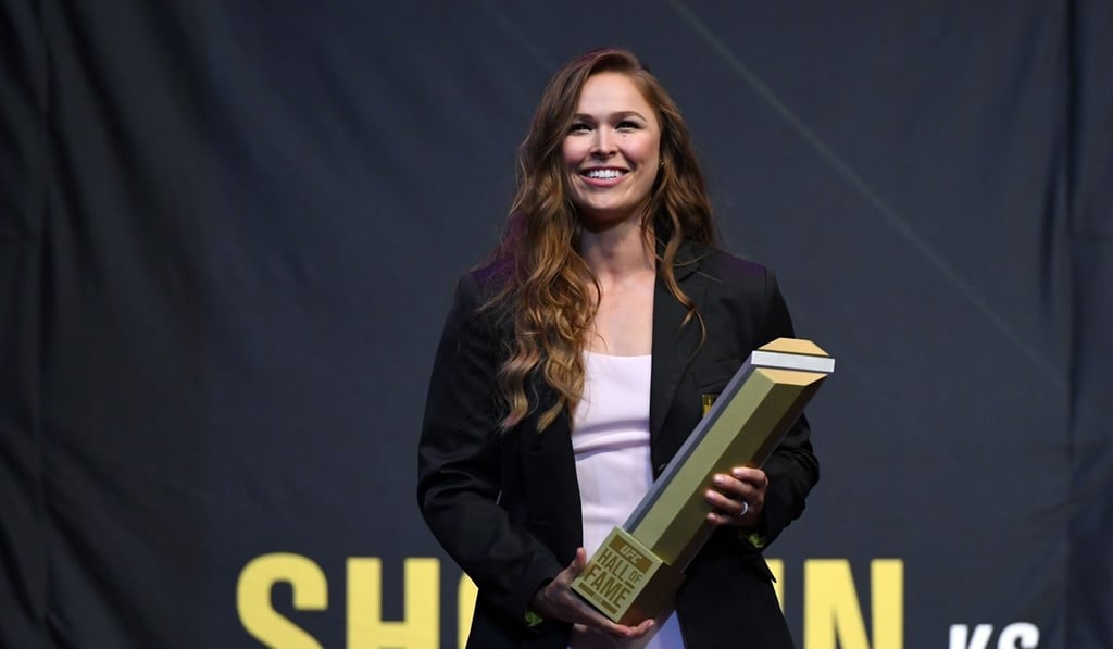 Ronda Rousey holds a trophy onstage after becoming the first female inducted into the UFC Hall of Fame. Photo: AFP