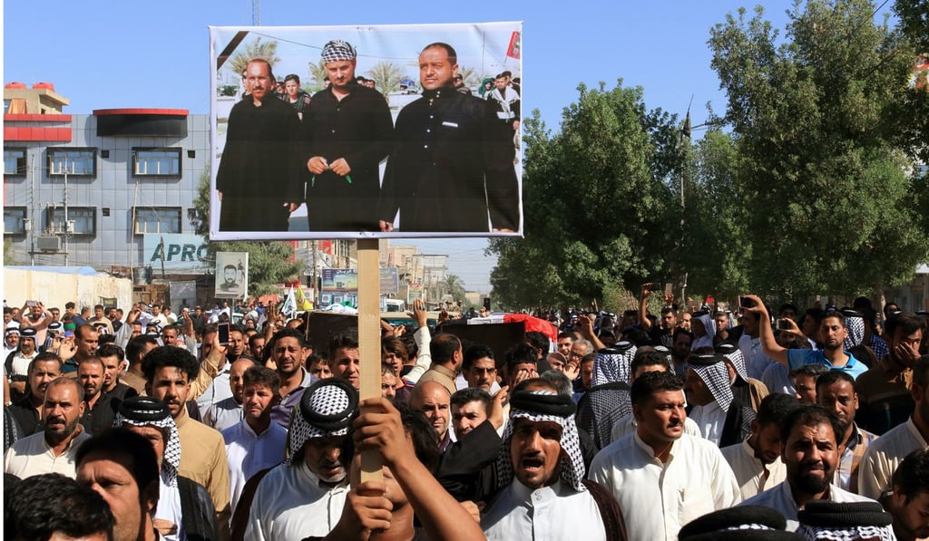 Iraqis carry the picture of victims who were kidnapped and then executed by the Islamic State group during a funeral procession in Karbala city, southern Iraq, on June 28. Photo: EPA