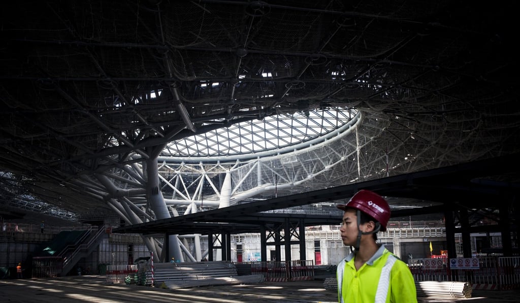 A worker stands inside a terminal building under construction at Beijing's new international airport in the Daxing district of Beijing, China. Photo: Bloomberg
